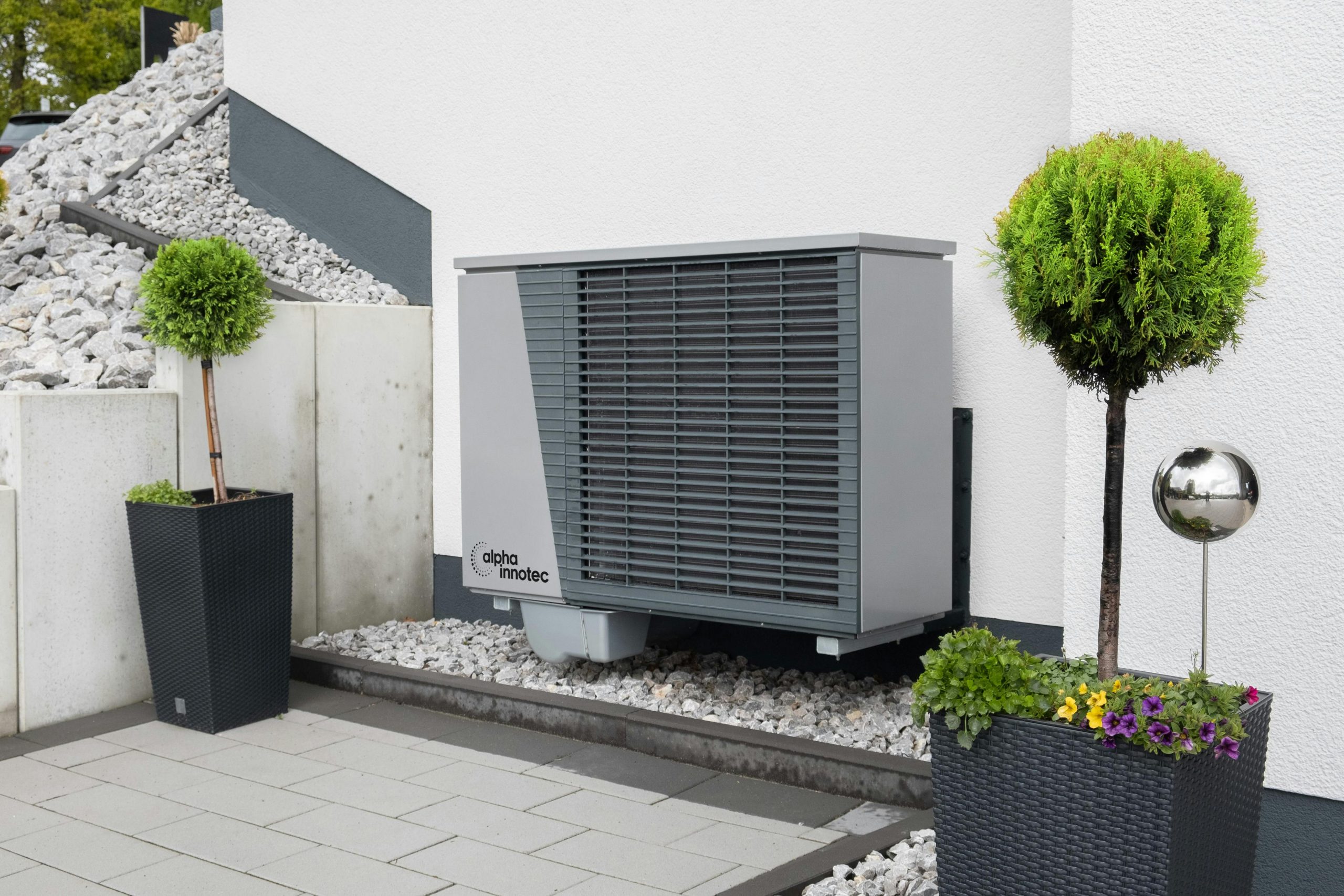 Modern air conditioning unit with flower pots and sleek decor outdoors.
